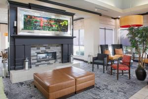a living room with a fireplace and a table and chairs at Hilton Garden Inn Jonesboro in Jonesboro