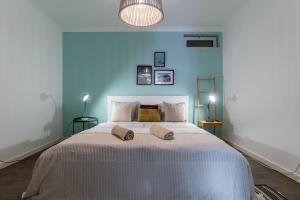 um quarto com uma cama grande e uma parede azul em Beach House Clerigo - 2 Unique Apartments em Aljezur