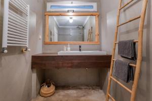 uma casa de banho com um lavatório, um espelho e uma escada em Beach House Clerigo - 2 Unique Apartments em Aljezur