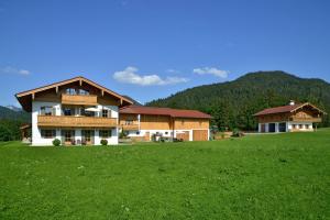 una casa grande en un campo con un campo verde en Weber am Gasteig, en Reit im Winkl