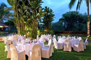 una recepción de boda con mesas y sillas blancas en Hilton Kuching Hotel, en Kuching