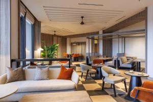 a lobby with couches and chairs and tables at Hilton Kuching Hotel in Kuching