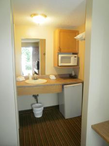 a small kitchen with a sink and a microwave at Bayview Inn Orillia in Orillia