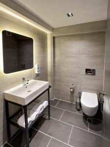 y baño con lavabo y aseo. en THE ROYALS HOTEL en İzmir
