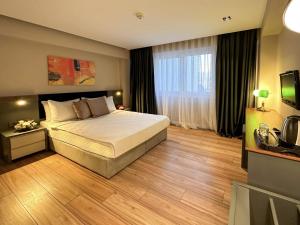 Habitación de hotel con cama y TV en THE ROYALS HOTEL en İzmir