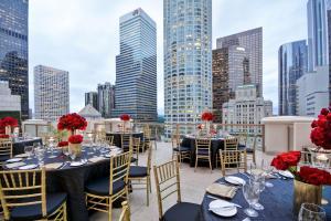 a balcony with tables and chairs and a city skyline at Hilton Checkers Los Angeles in Los Angeles