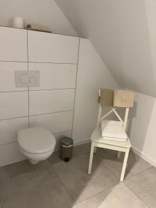 a bathroom with a toilet and a chair at Reiterhof Zwei Linden in Melle