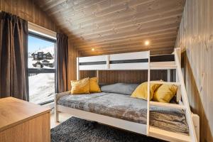 a bedroom with a bunk bed and a window at New lovely cabin in Rauland, ski inout, fast wifi in Torvetjørn