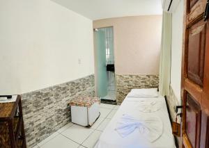 莫羅聖保羅的住宿－Pousada Timbalada，小房间设有两张床和镜子