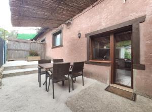 Un patio con mesa y sillas y un edificio. en Saika Rural, en Manjirón