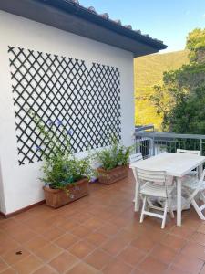 un tavolo bianco e sedie su un patio di Sunlight Apartment a Procchio