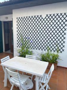 ein weißer Tisch und Stühle auf einer Terrasse in der Unterkunft Sunlight Apartment in Procchio