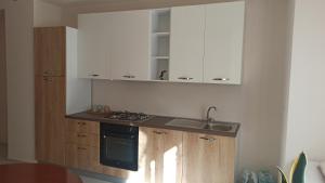 a kitchen with a sink and a stove and cabinets at Dimora CartaPane in Ariano Irpino +1 photo
