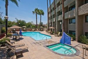 a swimming pool at a hotel with chairs and a building at DoubleTree by Hilton Rosemead in Rosemead