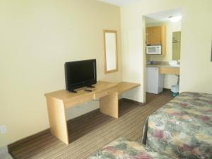 a hotel room with a desk with a television on it at Bayview Inn Orillia in Orillia