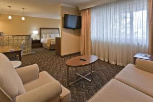 um quarto de hotel com um sofá e uma cama e uma televisão em DoubleTree by Hilton Rosemead em Rosemead