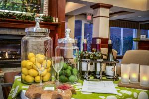 a table with bottles and glasses of wine and fruit at Hilton Garden Inn Lexington Georgetown in Georgetown