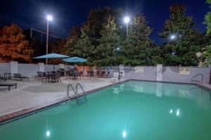 una piscina por la noche con mesas y sombrillas en Hampton Inn and Suites Lafayette, en Lafayette