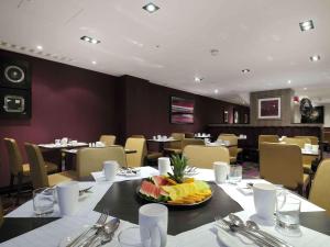 a restaurant with a table with a bowl of fruit on it at DoubleTree by Hilton London – West End in London