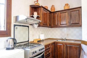cocina con armarios de madera y horno con fogones en Finikas House, en Palaikastro