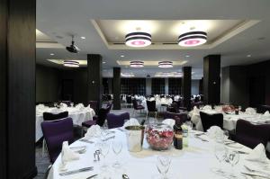 دبل تري من هيلتون لندن - ويست إند في لندن: غرفة طعام مع طاولات بيضاء وكراسي أرجوانية