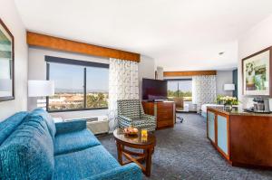 DoubleTree by Hilton Carson في كارسون: غرفة معيشة بها أريكة زرقاء وتلفزيون
