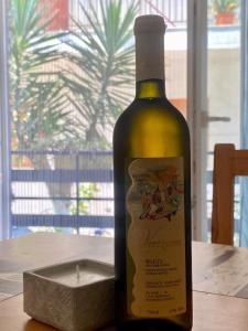 uma garrafa de vinho sentada numa mesa com uma vela em Nikoleta downtown apartment em Lefkada