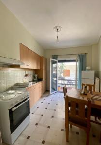 uma cozinha com uma mesa e um fogão forno superior em Nikoleta downtown apartment em Lefkada