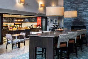 a bar in a restaurant with chairs and a counter at Hampton Inn & Suites Lincolnshire in Lincolnshire