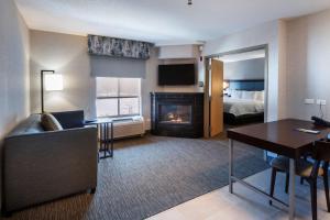 a hotel room with a fireplace and a bedroom at Hampton Inn & Suites Lincolnshire in Lincolnshire