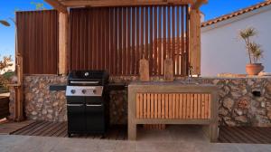 a outdoor kitchen with a stove and a table at Eunoia Porto Katsiki in Áyios Nikólaos Nirás