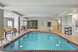 uma piscina no átrio do hotel com cadeiras e uma mesa em Hilton Garden Inn Conway em Conway