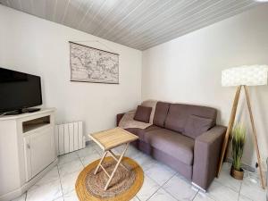 een woonkamer met een bank en een tv bij Maison 6 couchages Saint Cyprien in Saint-Cyprien