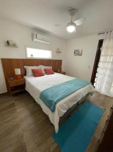 1 dormitorio con 1 cama grande con almohadas rojas y azules en Hotel Pousada Recanto das Árvores, en Búzios