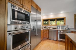 a kitchen with stainless steel appliances and wooden cabinets at Hidden Hollow in Bozeman