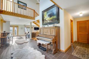 a living room with a piano and a staircase at Hidden Hollow in Bozeman