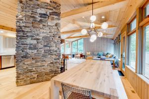 a large wooden table in a room with a stone wall at Mountain Adventures in Stowe