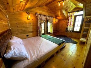 1 dormitorio en una cabaña de madera con 1 cama. en Doğada ahşap minik bir ev. ( Nazende Dağ Evi ), en Akcaabat