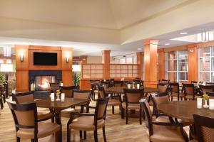 a restaurant with tables and chairs and a fireplace at Hilton Garden Inn Lancaster in Lancaster
