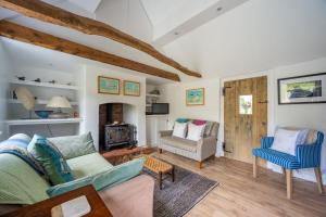 Myrtle Cottage في Friston: غرفة معيشة مع أريكة وكرسي