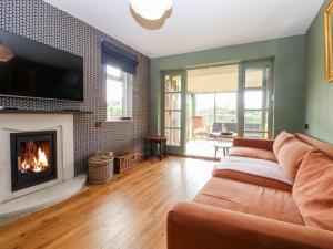 een woonkamer met een bank en een open haard bij Oak Meadow in Hastings