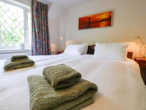 una camera da letto con un letto bianco e asciugamani di Oak Meadow a Hastings