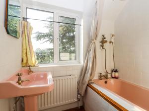 een badkamer met een wastafel, een bad en een raam bij Oak Meadow in Hastings +41 foto's