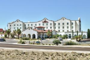 un grand bâtiment blanc avec une route devant lui dans l'établissement Hilton Garden Inn Las Cruces, à Las Cruces