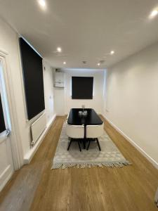 a living room with a black and white table and a tv at House by Araminta in Hounslow