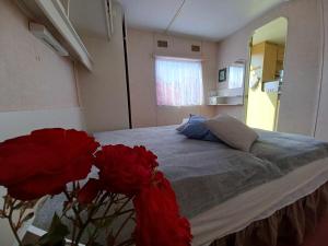 um quarto com uma cama com rosas vermelhas em DOMEK holenderski, Ogród, blisko plaży, Gdynia WAKACJE NA LUZIE em Gdynia