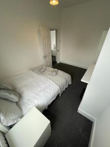 a bedroom with a white bed and a table at House by Araminta in Hounslow