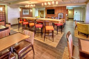 ein Restaurant mit einer Bar sowie Tischen und Stühlen in der Unterkunft Hampton Inn Midland in Midland