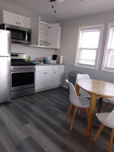 a kitchen with white cabinets and a table and a table and chairs at Dupont Beach House C in Seaside Heights