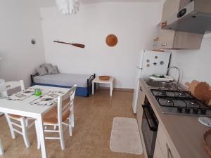 a kitchen with a table and a kitchen with a stove at Casa Mare Ognina in Ognina